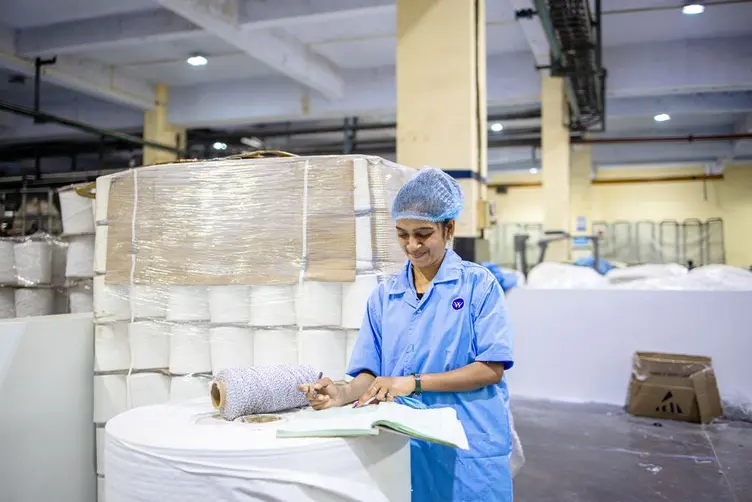 Worker holding a clipboard with paper job travelers